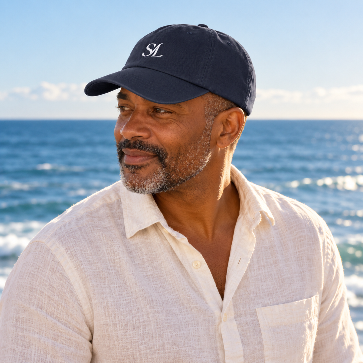Man in navy Saltline SL cap looking left with open ocean behind him