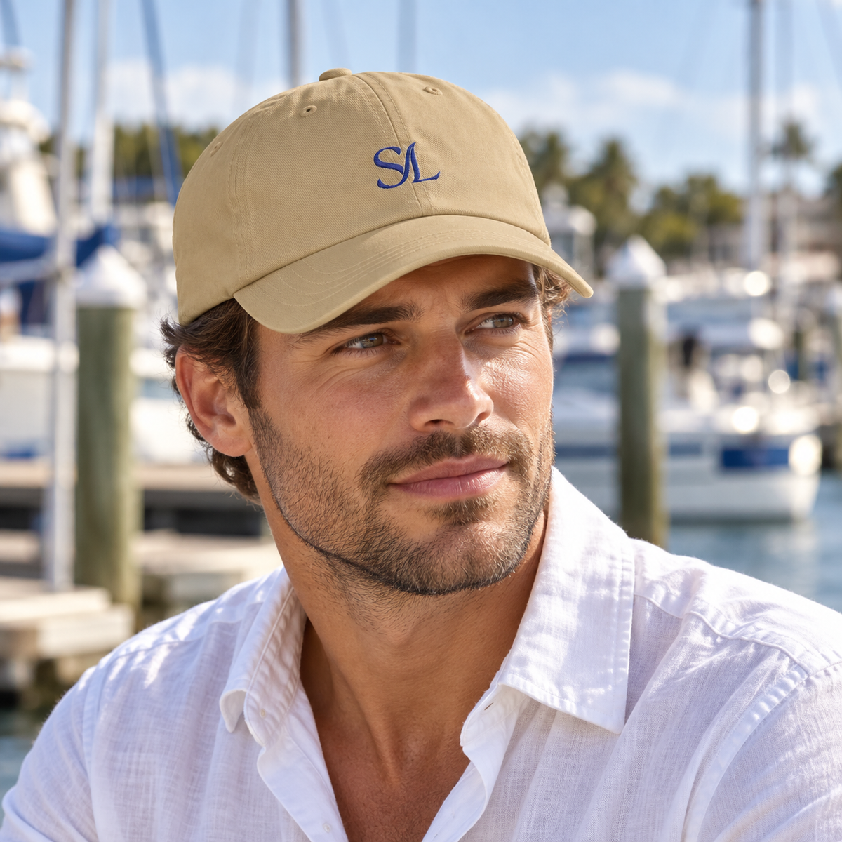 Man wearing Coastal Sand Logo Cap, close view of navy SL embroidery