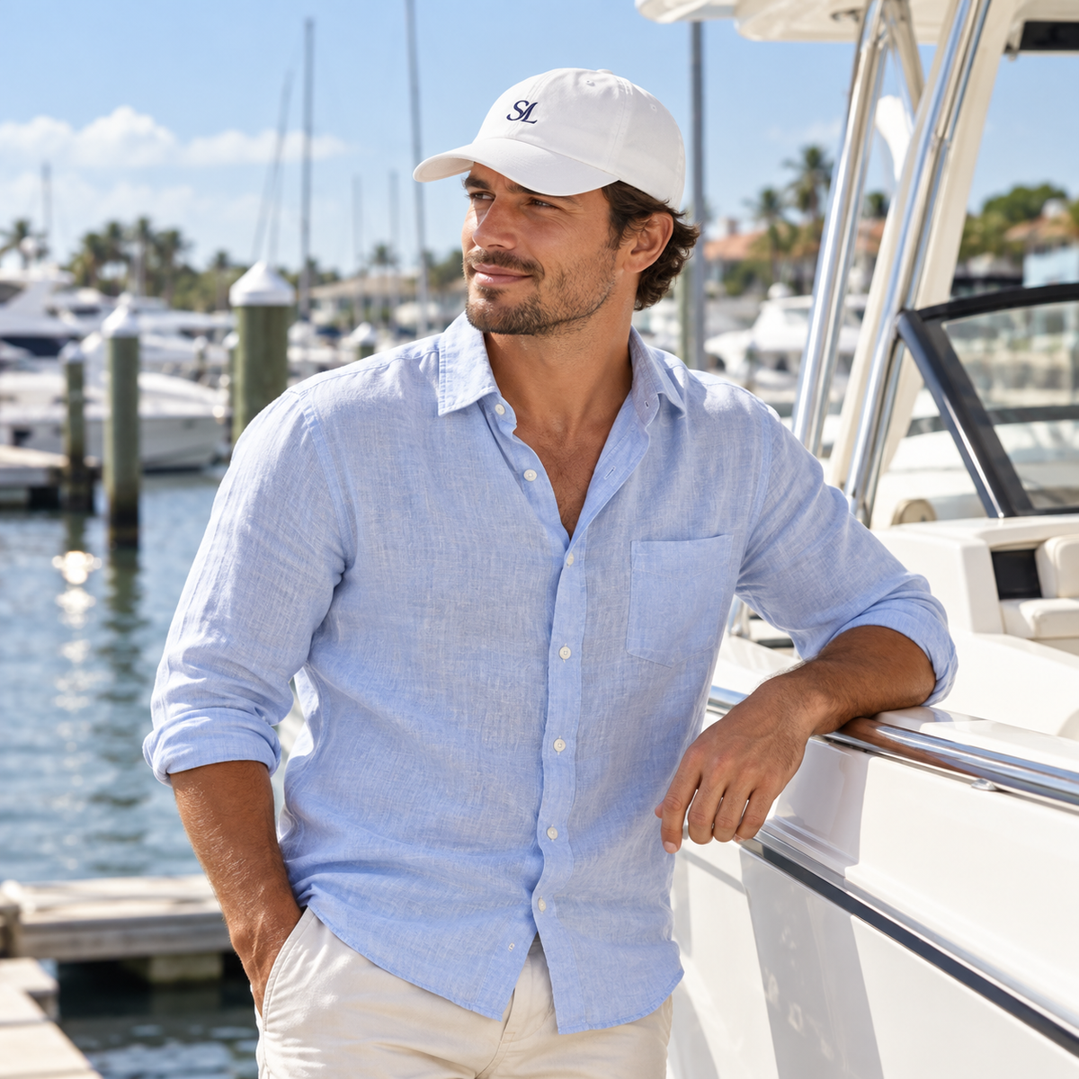 Man wearing Coastal White Logo Cap outdoors on the coast, wider view