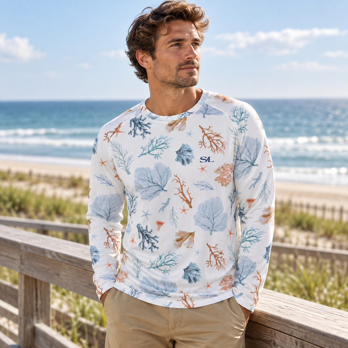 Man wearing Seaside Coral Sun Shirt in a coastal setting